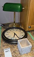 Lamp, clock and planter grouped together on countertop