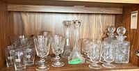 Entire lot on shelf showing candlesticks, decanters, glasses