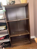 Front view of brown laminate bookcase showing shelves and overall form