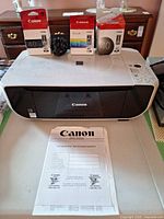 Printer with cartridges, power cord and manual displayed