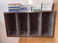 Front view of four-column rack with cassette tapes and CDs on top