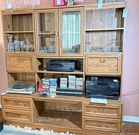 Full view of entertainment center with drawers, shelves, glass cabinet