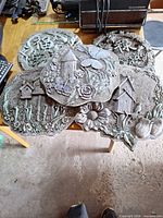 Group shot of five cast resin plaques stacked on table