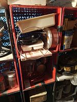 Crate showing plastic trays, metal rack, tins and various kitchen items