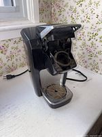 Front angle of Keurig B31 with brew head open showing staining and missing water reservoir