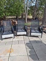 Front view of three black La-Z-Boy patio chairs on patio stones
