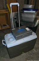 Rubbermaid wheeled cooler with telescoping handle extended, MyLand stove case on top