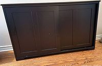 Front view of dark brown sideboard showing two sliding panel doors