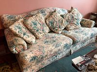Front view of floral 3-seat sofa with cushions and accent pillows