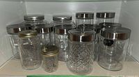 Front view of all glass jars showing variety of sizes and lids