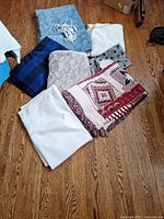 Group shot of all seven blankets laid on floor showing variety and electric controller