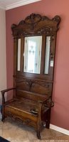 Full view of carved oak hall tree with mirror and bench