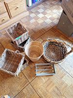 Assorted wicker baskets and metal rack laid out on floor