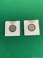 Both 1923 and 1924 Canadian 5-cent coins in flips on green background
