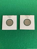Both 1929 5-cent coins in white cardboard holders, side by side
