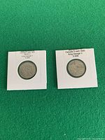 Front view of both slabbed coins in cardboard 2x2 holders