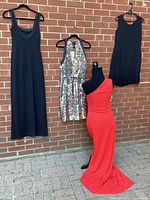 All four dresses hanging/mannequin against brick wall