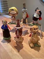 Front view of all six Looney Tunes porcelain decanter figurines on tabletop