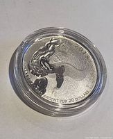 Coin obverse showing Superman in flight, year 2015 visible, in capsule