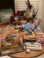 Overall view of assorted electronics, collectibles, toys and decor on tabletop