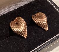 Pair of ribbed yellow gold earrings in black box, angled view