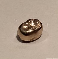 Top view of gold molar crown showing occlusal surface