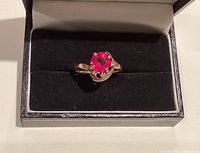 Front view of ring in box showing ruby and diamond accents