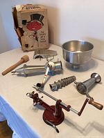 All components of strainer with apple corer and box displayed on table