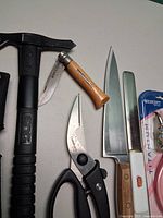 Group showing tomahawk, folding knife, chef’s knife, kitchen shears