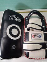 Front and back of two Fairtex kick pads showing overall design