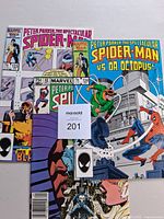 Three Spectacular Spider-Man comics overlapped showing issues 123 and 124 plus lower portion of another