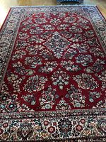 Full view of red floral wool area rug