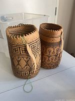 Two patterned cylindrical Ajat bags side by side