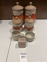 Group view of all four canisters with lids, creamer, sugar bowl, and toothpick holder