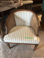 Front view of caned tub chair with striped upholstery