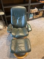 Front view of chair and ottoman displaying leather condition and wood bases