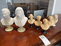 Seven bust figurines lined on furniture top