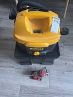 Top view of DeWalt vacuum on base with red vise in foreground