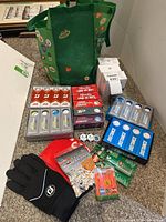 Overall view of boxed golf balls, tees, gloves, markers, cologne and bag