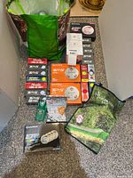 Full lot overview showing bag of loose balls, multiple boxed golf balls, tees pack, towel and cologne boxes