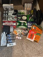 Full lot overview showing boxed golf balls, glove, towel, tees and accessories