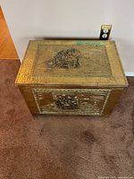 Top and side view of ornate brass-tone coal box showing embossed lid design and overall condition