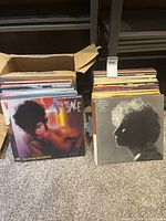 Box and stack of vinyl records; Prince and Barbra Streisand covers visible
