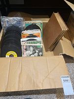 Open box showing stacks of 7-inch records and picture sleeves