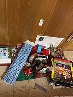 Pile of wrapping paper, gift bags, bows, tablecloths, baskets and window decor