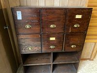 front view of cabinet showing six drawers with brass pulls and lower cubbies