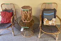 Two rattan armchairs, round glass-top table, hexagonal stand visible