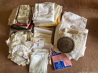 Overall pile of assorted linens and metal trivet