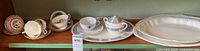 Shelf view of all items: platters, sugar bowl, teacups and saucers