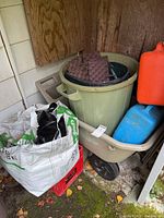 Overall view of wheelbarrow holding trash can, bag and other items